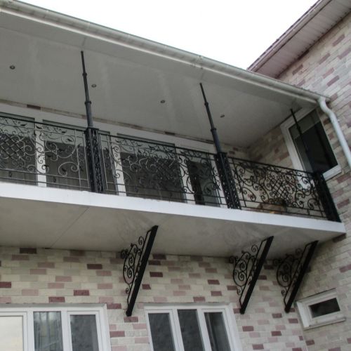 Балкон с коваными ограждениями и консолями