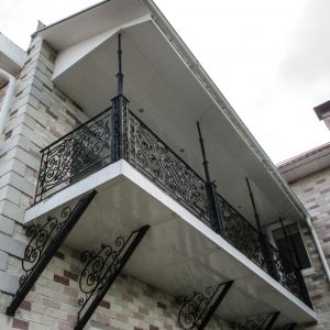 Балкон с коваными ограждениями и консолями